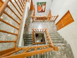 Una escalera con barandillas de madera y un muro de piedra.