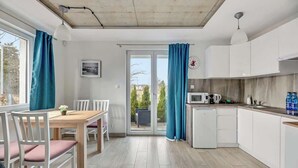 A modern kitchen with white cabinets, a microwave, and a sink.