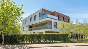 A modern two-story building with a balcony, a clear sky, and a hedge in the foreground. - Gdynia Orłowo | 450 metres to the Beach (Gdynia)