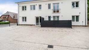 Un edificio residenziale a due piani con vialetto lastricato e cancello.