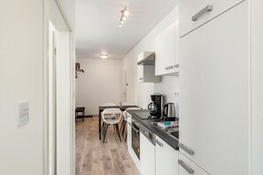 Cafetera o tetera, frigorífico, horno y placa de cocina
