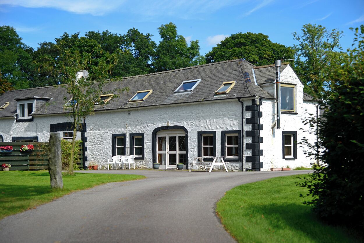 A white building with multiple windows, a door, and a small porch area.