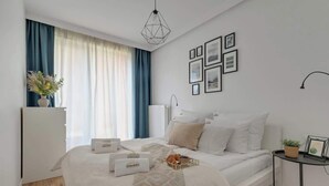 Ein Schlafzimmer mit einem Bett, Nachttischen, einer Lampe und einem Fenster mit Vorhängen.
