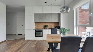 A modern kitchen with white cabinetry, a wooden countertop, and a built-in oven. - Bastion Wałowa 10 | City Center | Parking (Gdańsk)