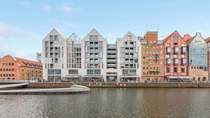 Een hotel aan het water met moderne architectuur, meerdere verdiepingen en een steiger.