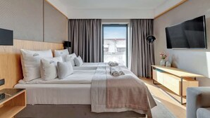 A hotel room with a large bed, a TV, a desk, and a view of the city. - Deo Plaza 515B | Nice City View | Hotel standard (Gdańsk)