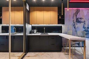 A modern kitchen with a marble countertop, black cabinets, and gold accents. - Nadmotławie291 | Jacuzzi Suite | Riverside & Sauna (Gdańsk)