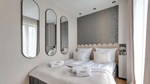 Ein modernes Schlafzimmer mit einem Bett, drei Spiegeln und einer Wand mit Muster.