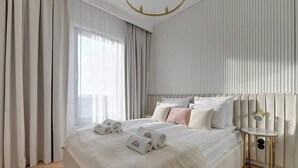 Ein modernes Hotelzimmer mit einem großen Bett, einem Nachttisch und Blick auf die Stadt.