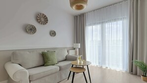 En moderne stue med sofa, rundt sofabord og lampe.