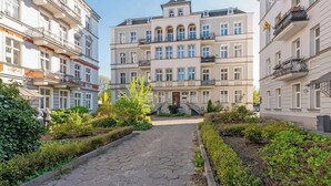 A multi-story building with a central courtyard, balconies, and a clear sky. - Grunwaldzka Attic | Great Location | Family Stay (Gdańsk)
