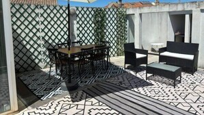 A patio with a table and chairs, an umbrella, and patterned flooring. - Roof terrace apartment in Avignon (Avignon)
