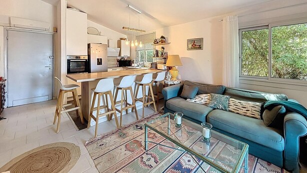 Un espacio habitable moderno con cocina, zona de bar y asientos.