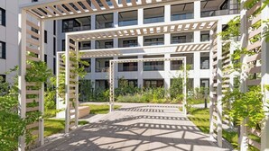 A multi-story building with a covered outdoor area featuring a pergola structure.