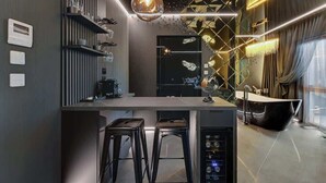 Une cuisine moderne dotée d’un îlot central, de tabourets de bar, d’un four encastré et d’une grande fenêtre.