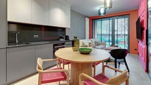 Una cocina moderna con comedor, sofá y televisor.