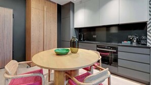 Una cocina moderna con una mesa redonda, sillas y un horno empotrado.