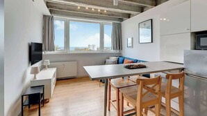 Una cucina moderna con zona pranzo, ampie finestre e vista sulla città.