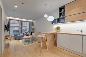 Eine moderne Küche mit Barbereich, Holzausstattung und einem großen Fenster mit Jalousien.