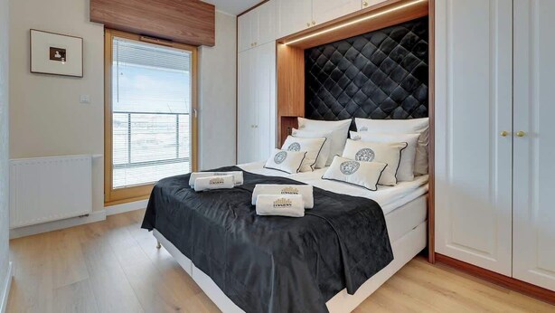 Ein Schlafzimmer mit Bett, Fenster und Einbauschrank.