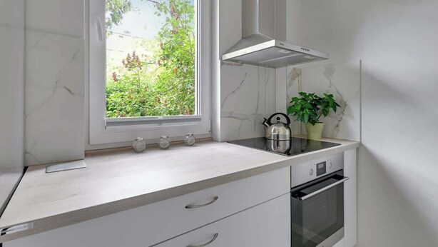 A kitchen with a window, a stove, and a plant. - Chłopska 2 | Near the Beach (Gdańsk)