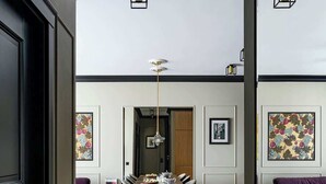 A dining area with a table set for four, a sofa, and a patterned floor. - Tarasy Bałtyku 73 | Seaside | Billard, Sauna & Gym (Gdańsk)