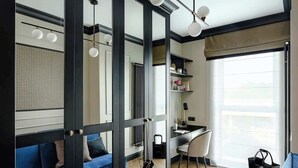 A modern interior with a blue sofa, a desk, and a sliding glass door leading to another room. - Tarasy Bałtyku 73 | Seaside | Billard, Sauna & Gym (Gdańsk)