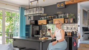 Moderni keittiö, jossa on keskeinen saareke, integroidut kodinkoneet ja näkymä vehreään maisemaan.