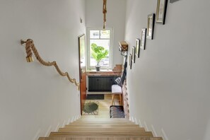 A staircase leading to a room with a radiator, a potted plant, and a chair. - House 200 metres to the Sopot beach | Beach & Park (Sopot)
