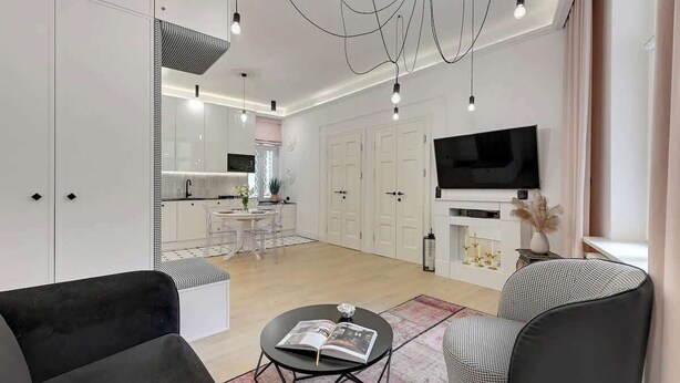 A modern living room with a sofa, a coffee table with a magazine, a TV, and a fireplace. - 500 metres to the Sopot Beach | Monte Cassino (Sopot)