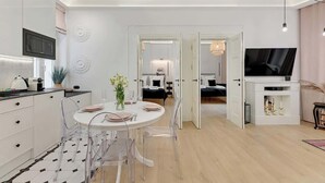 A modern kitchen with a dining area, a TV, and a bedroom visible through an open door. - 500 metres to the Sopot Beach | Monte Cassino (Sopot)