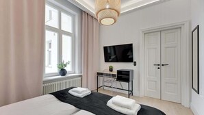 A modern bedroom with a bed, a desk, a TV, and a wardrobe. - 500 metres to the Sopot Beach | Monte Cassino (Sopot)