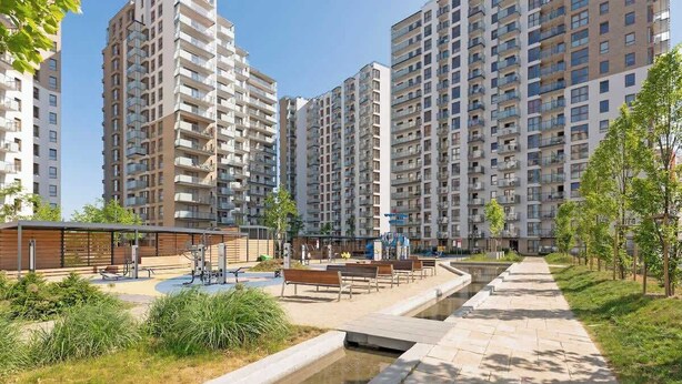 A residential area with high-rise apartment buildings, a small park with benches, and a water feature. - Letnica 147 with Balcony | Seaside (Gdańsk)