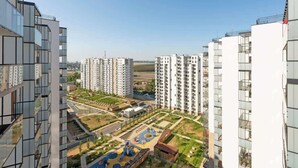 A high-rise residential building with multiple balconies, a playground, and a clear sky. - Letnica 147 with Balcony | Seaside (Gdańsk)