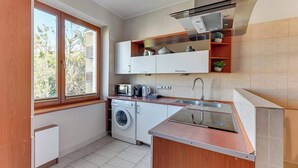 A compact kitchen with a washing machine, microwave, and built-in oven. - Gdynia | 800 metres to the beach | City Centre (Gdynia)