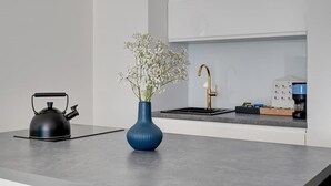 Eine moderne Küche mit Wasserkocher, Blumen in einer Vase und einer Kaffeemaschine.