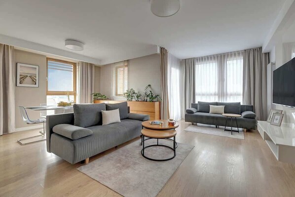 Una sala de estar moderna con un sofá, una mesa de centro y un televisor.