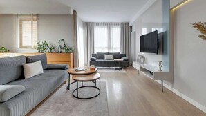 Un salon moderne avec un canapé, une table basse et un téléviseur.