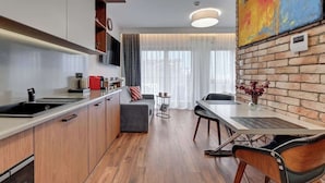 Eine moderne Küche mit Essbereich, Holzboden und einer Wand aus Ziegelsteinen.