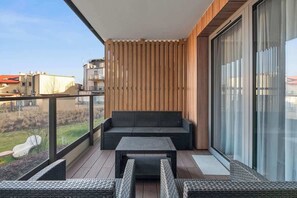 A balcony with a sofa, a table, and wicker chairs. - Merwede Residence 112 | by the Beach (Gdańsk)