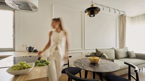 Et moderne køkken med spiseplads, en sofa og et bord med en skål.