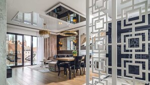 A modern interior with a dining area, a staircase, and a view of the city. - Deo Plaza 306 | View of the river and the Old Town (Gdańsk)