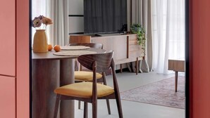 A modern dining area with a TV, wooden furniture, and a plant. - Doki G230 | Gdańsk Shipyard & Foodhall (Gdańsk)