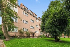 Un immeuble résidentiel à plusieurs étages, doté d’un toit plat, d’une entrée principale et d’une pelouse bien entretenue.