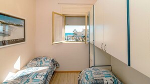 Ein Schlafzimmer mit zwei Betten, einem Fenster mit Blick und einem Kleiderschrank.