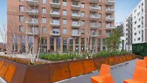 A modern building with multiple balconies, a rooftop garden with seating, and a clear sky. - Żurawie B100B | Shipyard | Foodhall Montownia (Gdańsk)