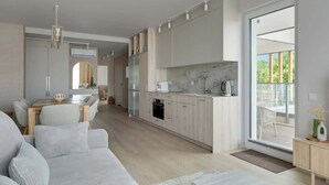 Eine moderne Küche mit Marmor-Spritzschutz, Holzschränken und einem Essbereich mit einer Couch und Stühlen.
