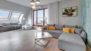 Un salon moderne avec un canapé, une table basse et des œuvres d’art accrochées au mur.