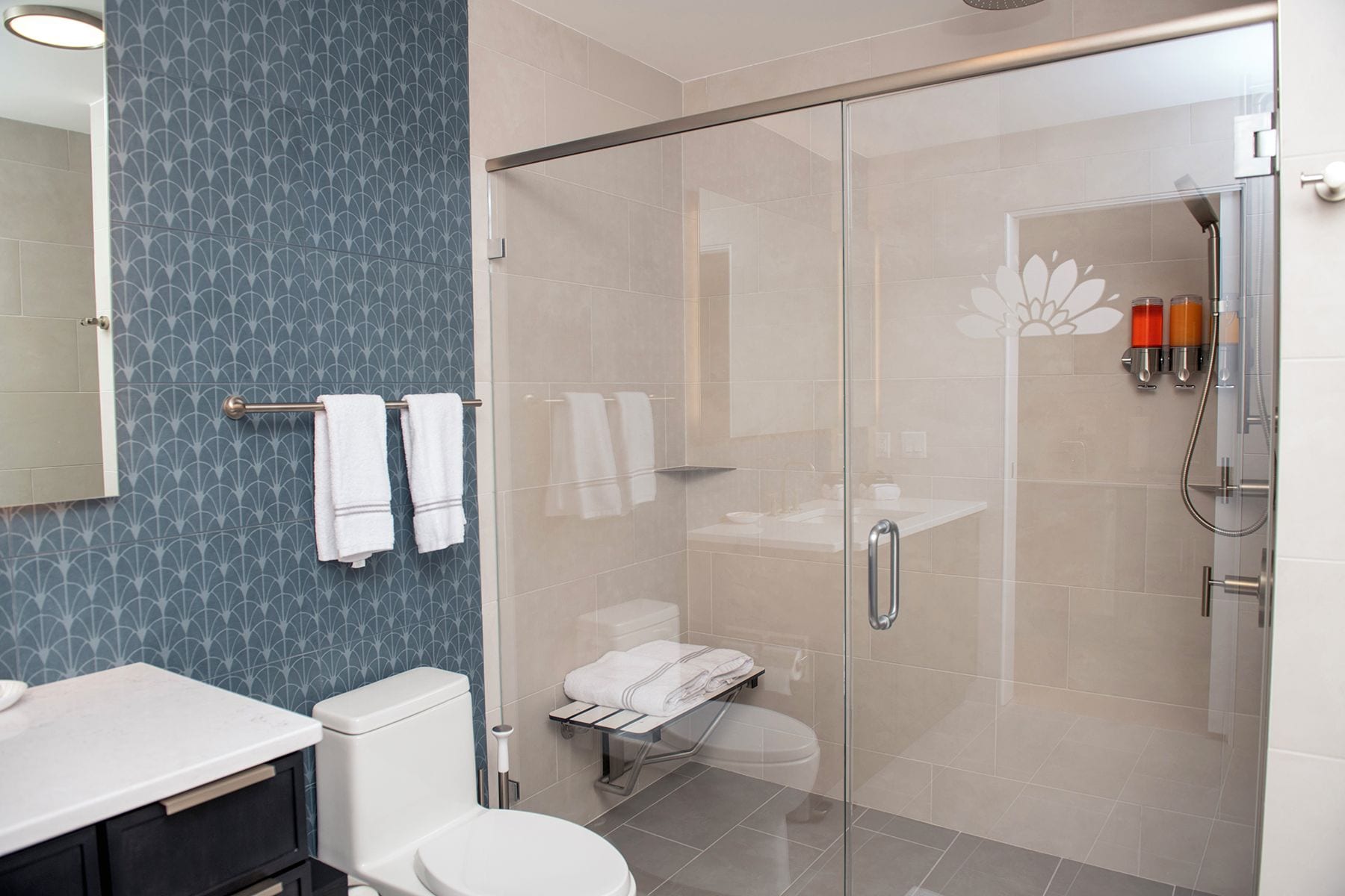 A modern bathroom with a glass shower enclosure, a toilet, and a sink.