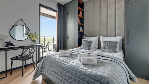 Ein modernes Schlafzimmer mit Bett, Schreibtisch, Stuhl und Kleiderschrank.